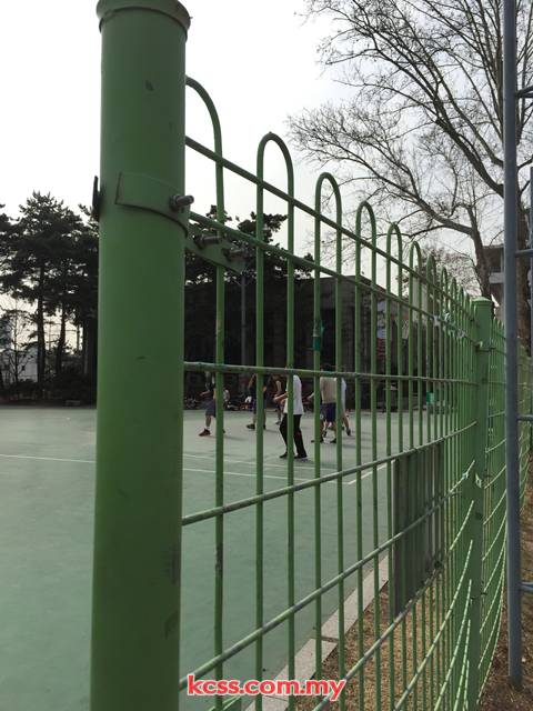 KCSS green roll top fence installed around a sports court