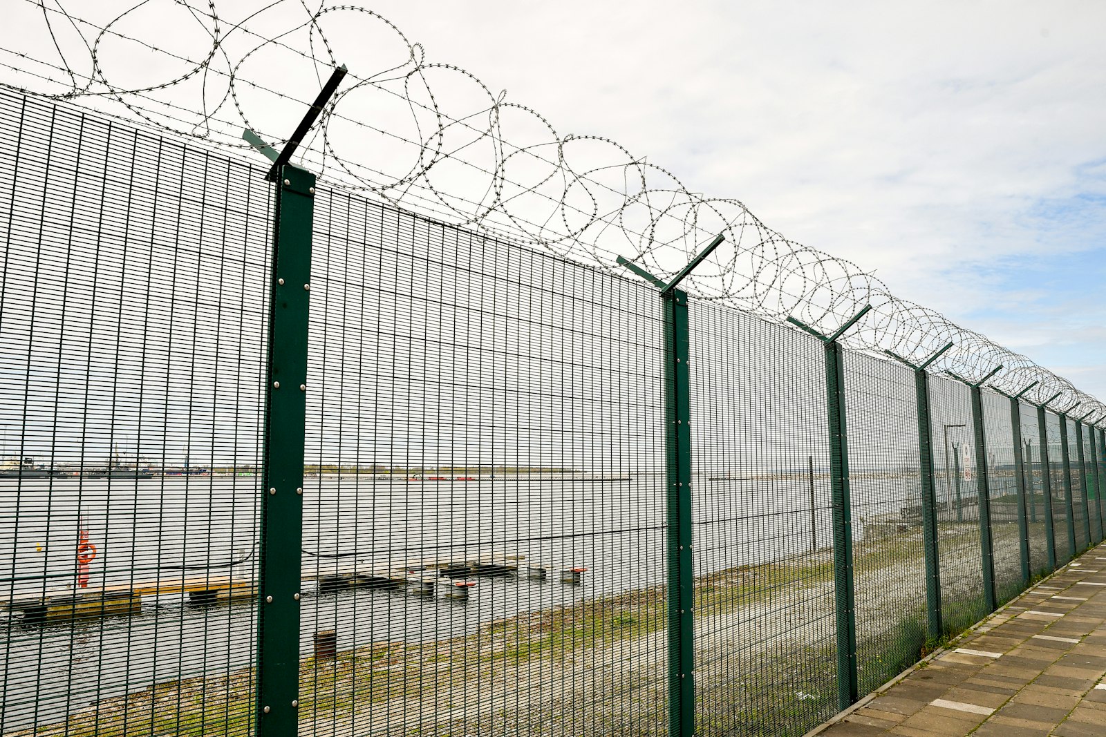 Welded mesh security fence topped with razor wire