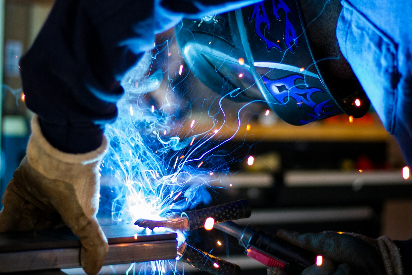 Welder in protective gear welding steel